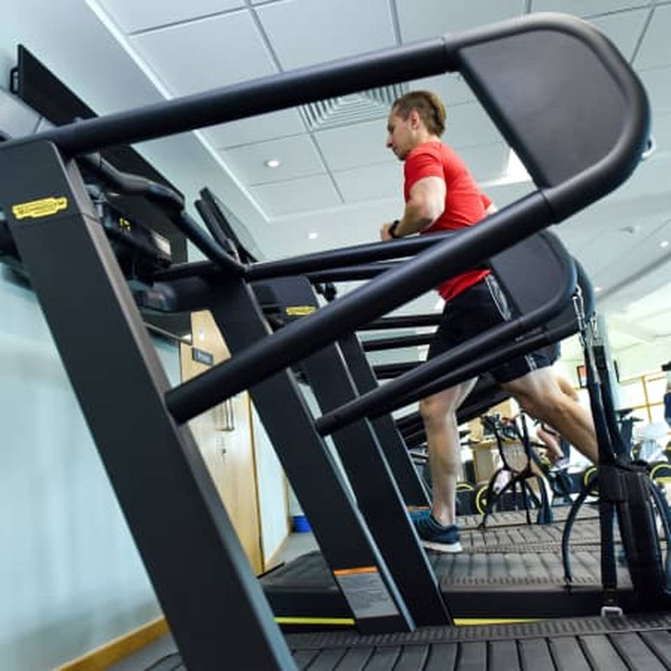 A female health club member running on a treadmill at Castle Royle's gym